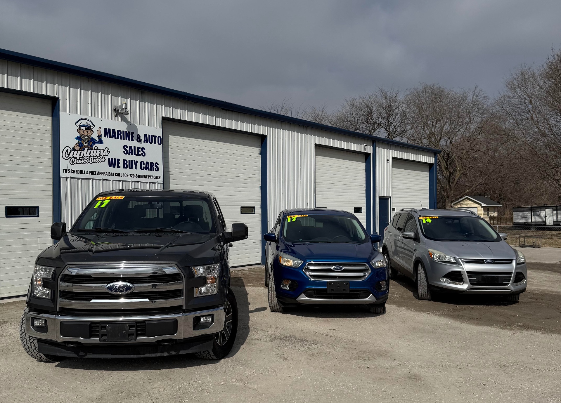 Captain's Choice Marine & Auto Sales lot with trucks and SUVs in front of the showroom